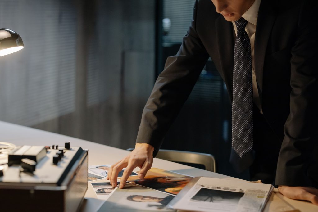 Private investigator reviewing case documents at a desk